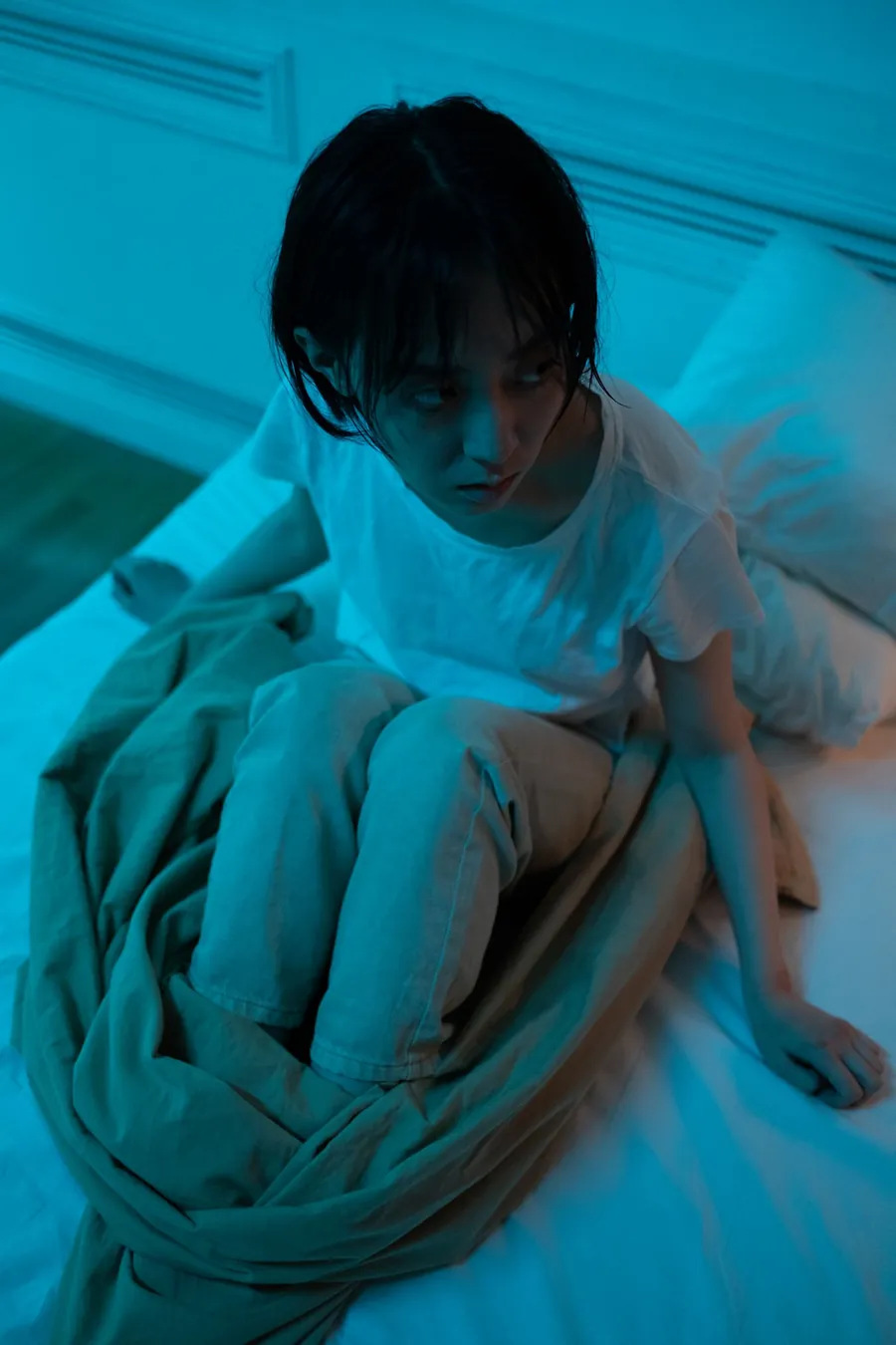 Woman wrapped in a blanket at night with night sweats before her period